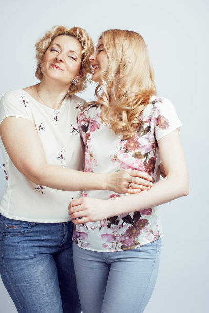 母亲与女儿一起摆出幸福的微笑孤立在白色的背景与copyspace，生活方式的人概念特写图片下载