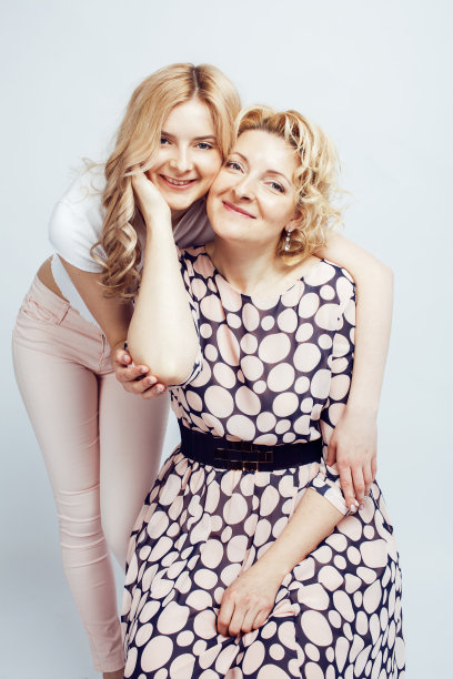 母亲与女儿一起摆出幸福的微笑孤立在白色的背景与copyspace，生活方式的人概念特写图片下载