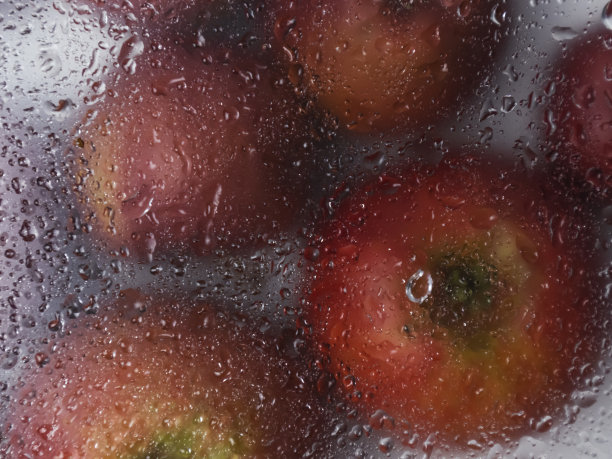 苹果的背景玻璃后面有雨滴图片下载