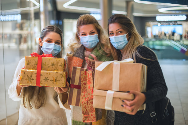 COVID-19大流行期间，一家人在购物中心享受圣诞购物。他们戴着防护口罩，以预防冠状病毒COVID-19。图片下载