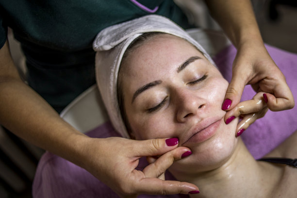 美丽的女人在水疗沙龙的面部按摩-抗衰老疗法-年轻化和面部清洁图片下载