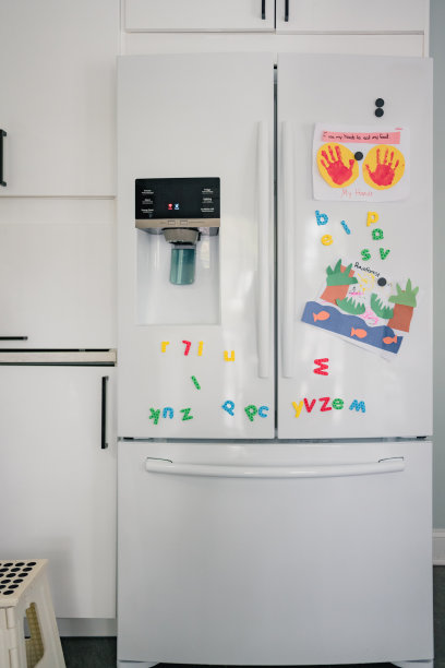 有字母磁铁和儿童艺术品的冰箱图片下载