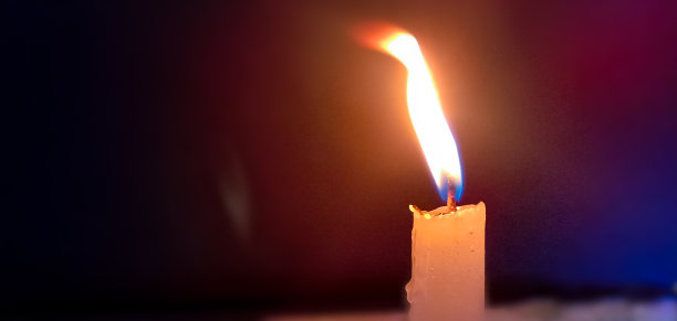 燃烧的蜡烛。景深浅。圣诞蜡烛在夜晚燃烧。抽象的蜡烛背景。烛光在黑暗的背景上发光。特写镜头。自由空间。图片下载