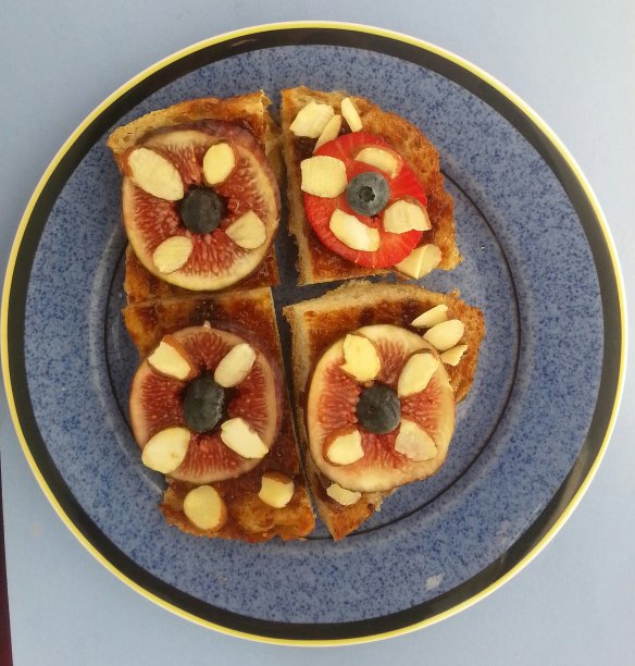 一个蓝色盘子上的无花果和草莓三明治的特写图片下载