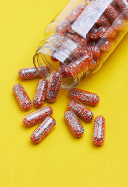 胶囊药丸装在一个瓶子里，在黄色图片下载
