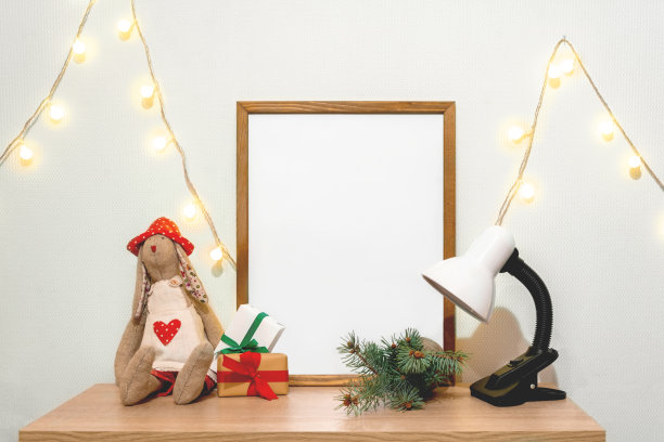 圣诞海报框架模拟。手工制作的娃娃绿杉木树枝红纸礼品盒灯花环灯图片下载