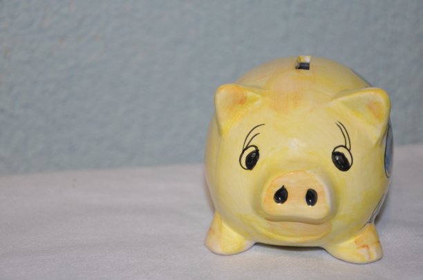黄色储蓄罐或钱箱孤立在蓝色背景。图片下载