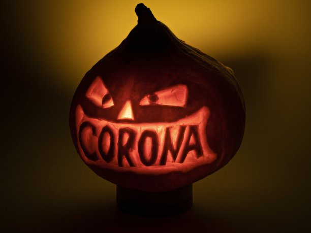 刻有电晕字的万圣节南瓜在黑暗中发光图片下载