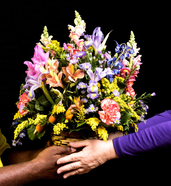 以黑人为背景，由非裔美国人的男性双手赠送给白人女性的彩色花束。多样性，母亲节，爱或情人节的概念图片下载