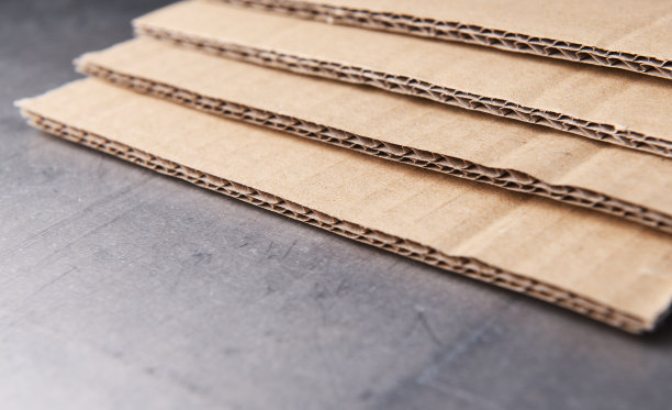 棕色瓦楞纸板在灰色钢背景上。图片下载