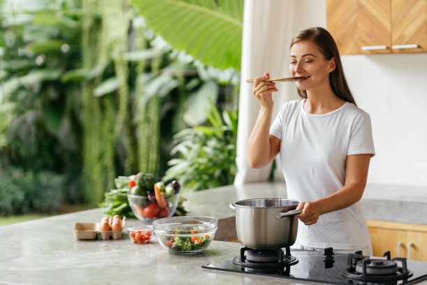 漂亮的白人妇女的照片拿着勺子，而吃汤与新鲜的蔬菜图片下载