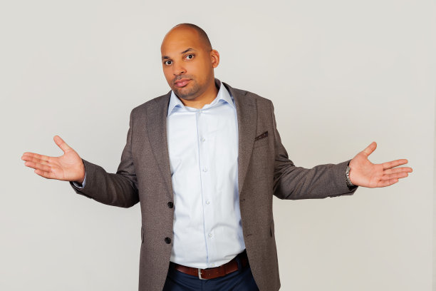 一个心怀不满、紧张不安的年轻人，非裔美国商人，一副愤世嫉俗、愤怒的表情，摊开双手做了一个无助的手势，摊开手掌，好像不知道该做什么。图片下载