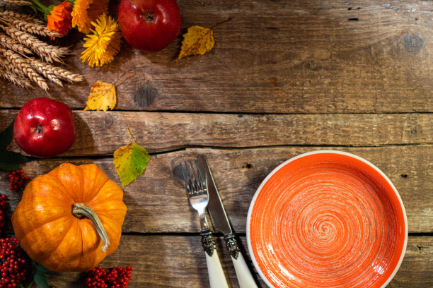 感恩节的背景。秋季餐桌设置感恩节聚会或感恩节晚餐。盘子，餐具，南瓜，花卉，水果和季节装饰在质朴的木桌上图片下载