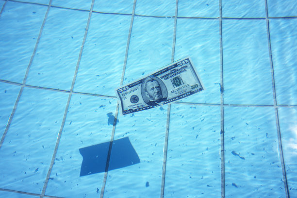 50美元的钞票在清澈的蓝色水面上游泳图片下载
