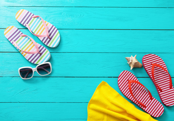 人字拖，太阳镜和贝壳在蓝色木制背景。复制空间和时尚的夏季配件。图片下载