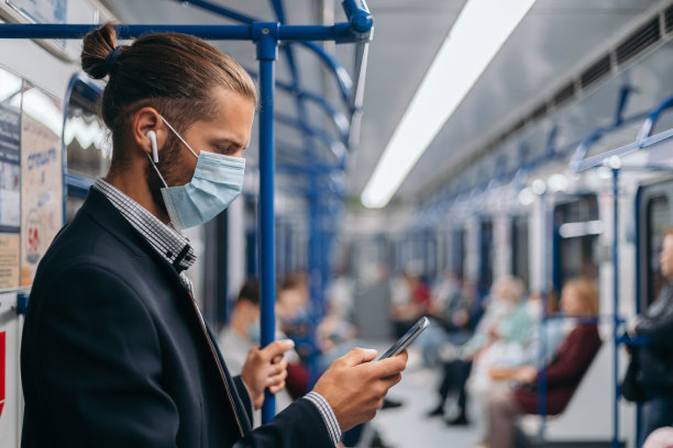 戴着防护面具的人站在地铁车厢里图片下载