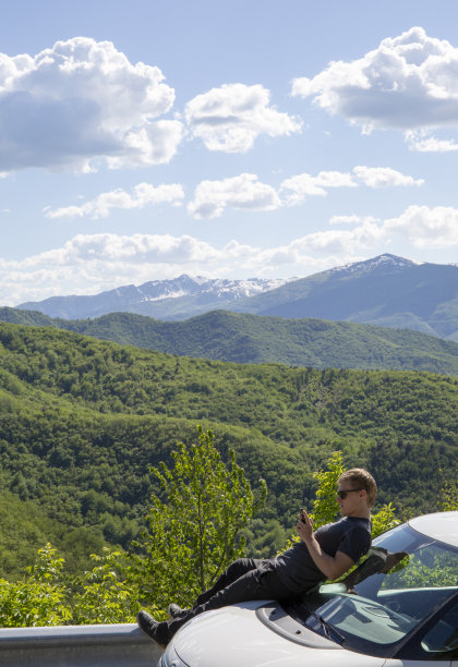 年轻人靠在车上，用手机发短信图片下载