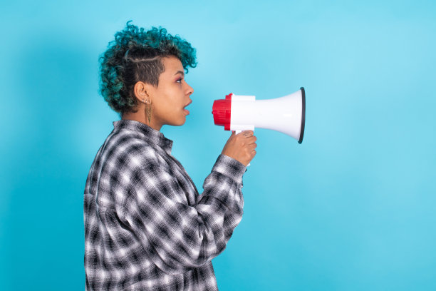 非洲裔美国女孩或妇女，扬声器被隔离在蓝色背景下图片下载