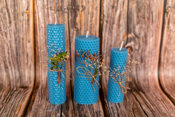 在木板的背景上用天然蜡手工制作的蓝色蜂蜜蜡烛。元素来自天然材料。圣诞或新年作文。照片的明信片。图片下载