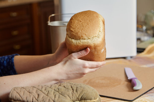 女主人保存新鲜面包从电面包机图片下载