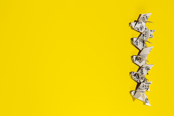 一群在黄色背景上飞翔的鸽子。图片下载