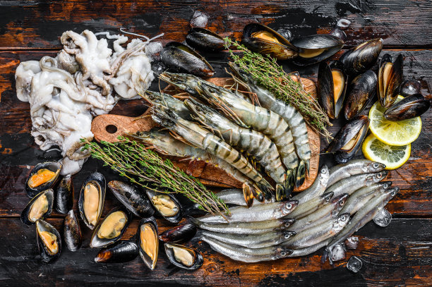 什锦海鲜虎虾、鲜虾、青贻贝、章鱼、沙丁鱼、香味俱全。黑暗woodden背景。俯视图图片下载