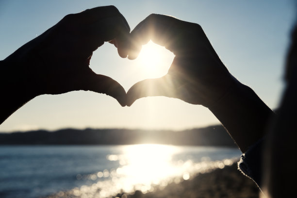 夕阳穿过心形的手图片下载