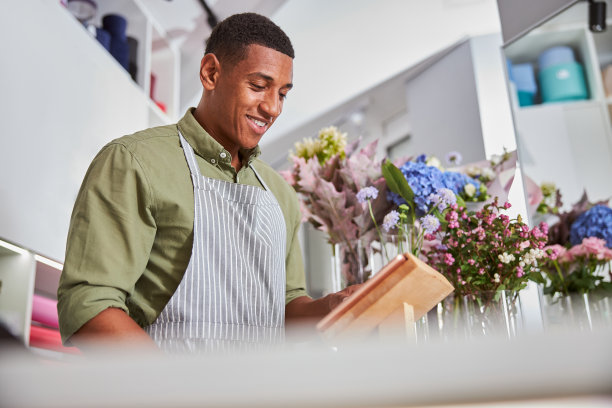 工作时在花店用触控板的快乐男人图片下载