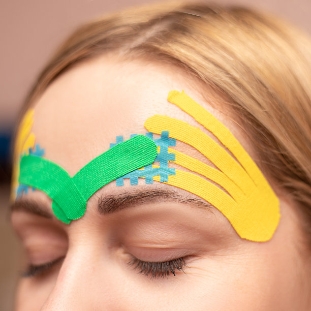 年轻女子做美容院整容手术的美容贴。自然的面部复兴。彩色kinesio磁带。整容术。人体运动学。美容和药品。皱纹在额头上图片下载