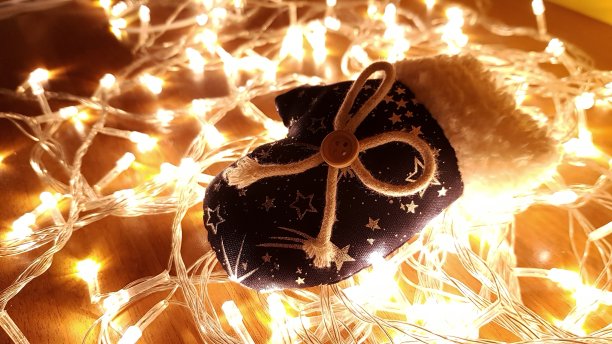 手工制作的圣诞玩具在发光的花环灯泡的背景图片下载