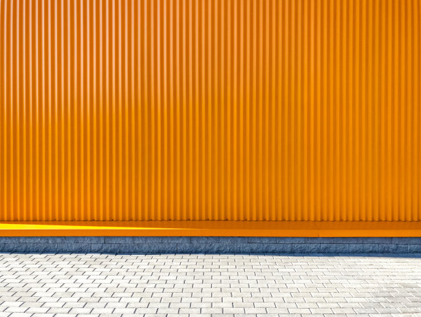 仓库的橙色波纹金属墙面。现代仓储建筑立面图片下载