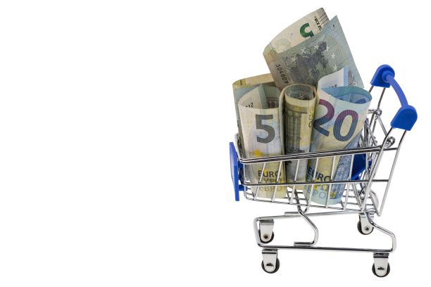 近宏观的购物车装满了滚动的欧元钞票孤立在白色的背景。图片下载