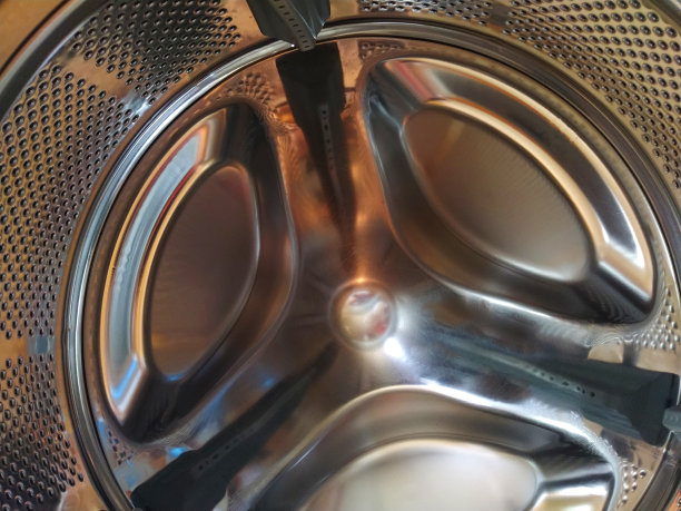 洗衣机的滚筒从里面。闪亮的金属罐，有孔和凸起。洗衣机的内部视图图片下载