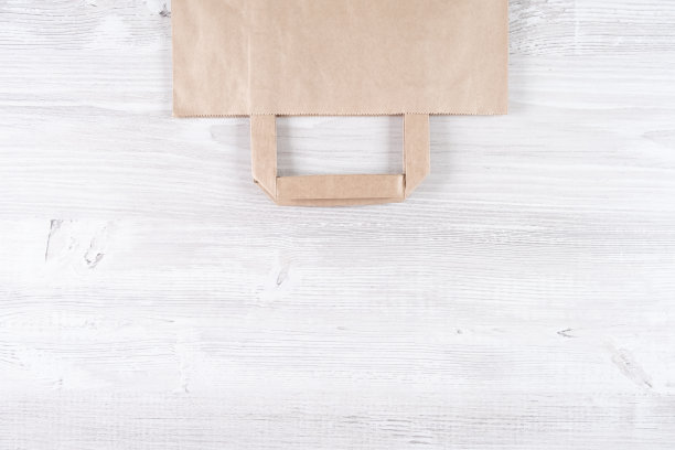 白色木桌上放着棕色环保纸袋。放置标识的位置图片下载