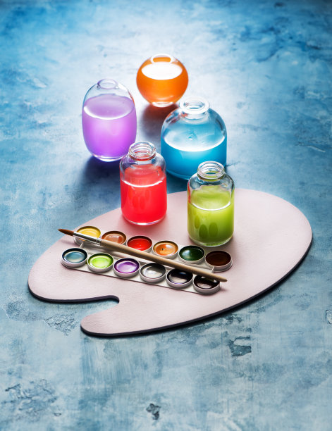 玻璃瓶里的彩色水彩颜料和画家的调色板。创造性的艺术背景图片下载