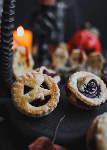 节日万圣节蛋糕与姜饼墓碑。黑暗的背景，南瓜，蜡烛和骷髅。图片下载