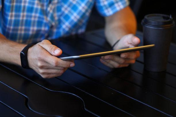 在咖啡馆里拿着小玩意的男人图片下载