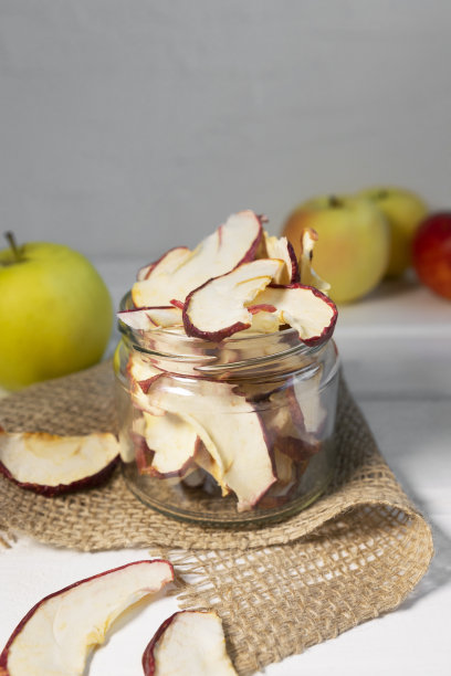 干燥的脱水苹果片在玻璃罐在白色的背景图片下载
