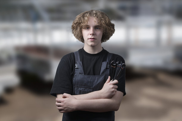 汽车技工与一个工具在一个模糊的背景。图片下载