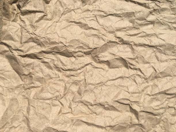 棕色皱巴巴的纸背景与复制空间的设计。皱巴巴的墙纸图案图片下载