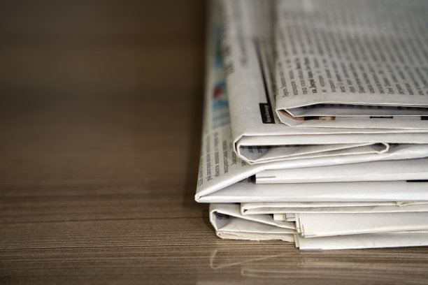特写的颜色堆叠的报纸在木桌子的背景图片下载