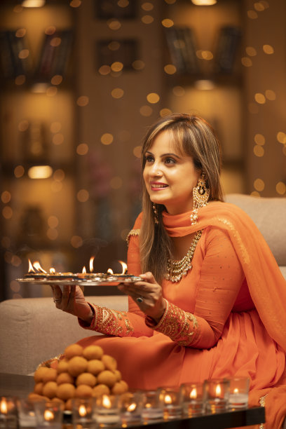 年轻女子在家里庆祝排灯节-库存照片图片下载