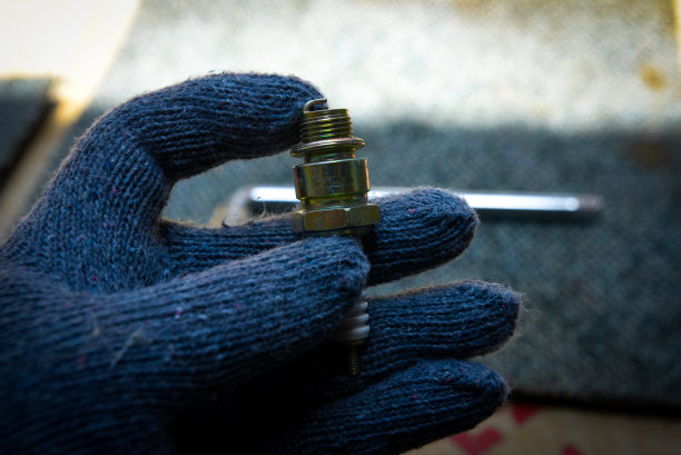 手持装有火花塞的手套图片下载