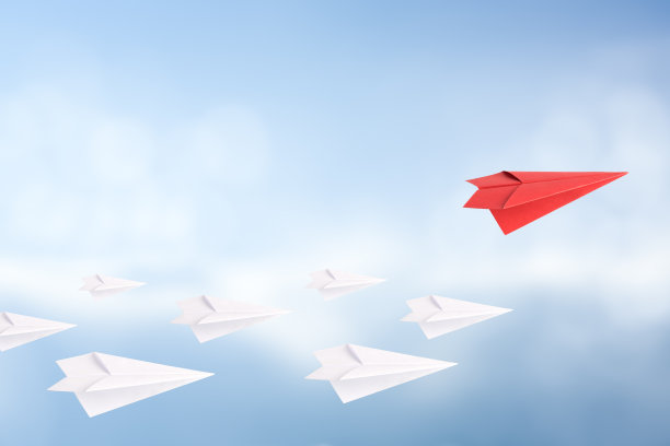 以红纸飞机领先于白纸飞机的领导理念。天空背景。图片下载