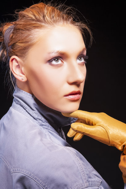 红色头发白种人女性与黄色手套的肖像黑色的背景。图片下载