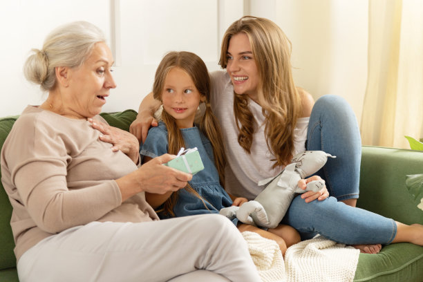 快乐的惊喜祖母的节日礼物从孙女和微笑的女儿图片下载