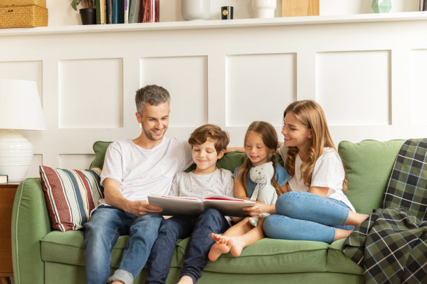 爱的夫妇和孩子一起在家里读书。快乐的亲子关系图片下载