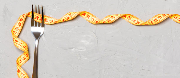 灰色背景上的叉子和卷尺的俯视图。饮食概念与复制空间图片下载