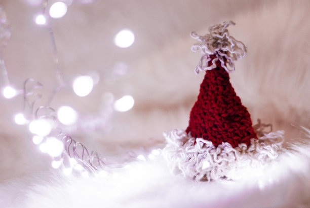 手工编织的圣诞帽在节日的灯光下图片下载