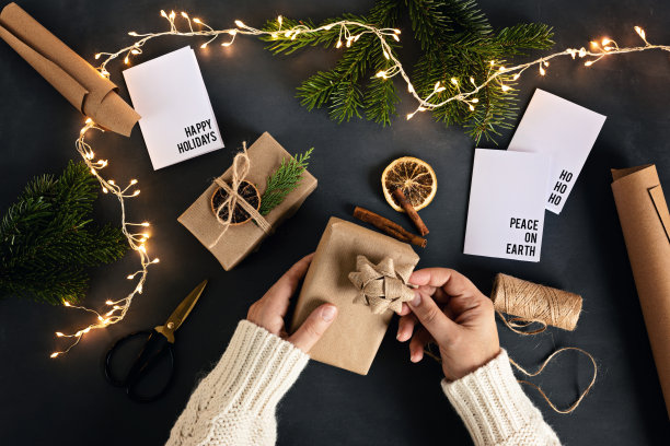 女人用可回收的牛皮纸包装环保的绿色圣诞礼物图片下载